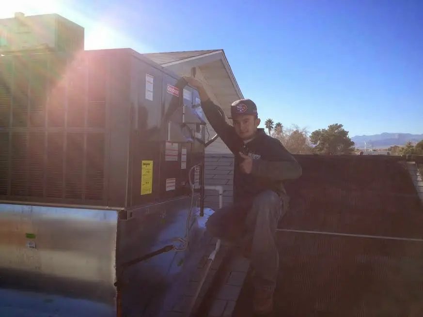 HVAC technician performing HVAC Inspection on a rooftop unit in Rochester